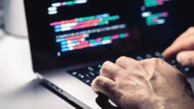 A modern office workspace with digital screens displaying cybersecurity threat warnings.