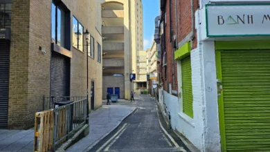 A narrow alley in Croydon overshadowed by a multi-storey car park.