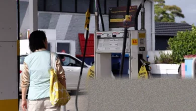 Aerial view of a queue of cars at a petrol station forecourt.