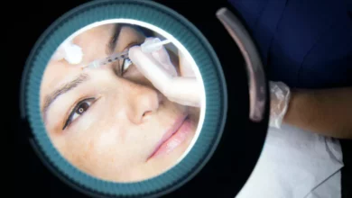A doctor in a clinical setting consulting a patient about facial aesthetics.