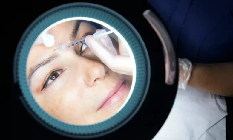 A doctor in a clinical setting consulting a patient about facial aesthetics.