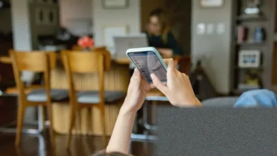 Teenagers using mobile phones in a UK classroom setting.