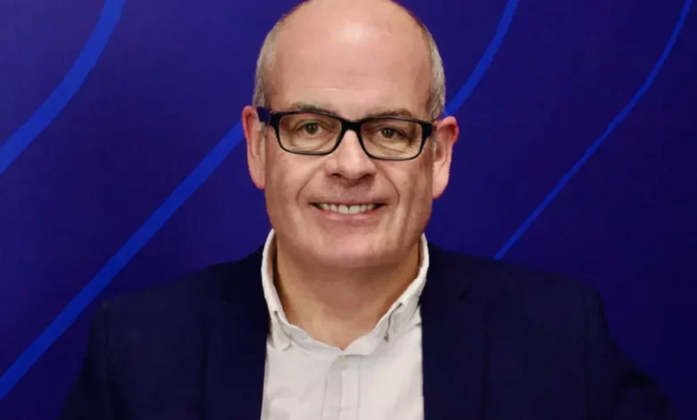 A business professional discussing Microsoft E7 and agentic AI adoption at a corporate event.