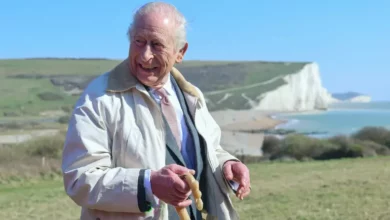 King Charles walking on the coastal path wearing walking boots.