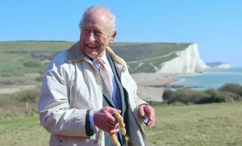 King Charles walking on the coastal path wearing walking boots.
