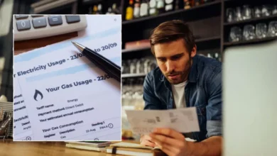 A publican checks energy usage data on a tablet in a busy pub kitchen.