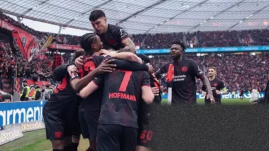 Bayer Leverkusen players celebrating a goal against Bayern Munich in a Bundesliga match.
