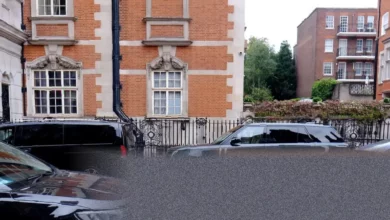 A large black SUV parked on a narrow London street.