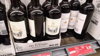 A selection of French wine bottles and European food staples on a shelf.