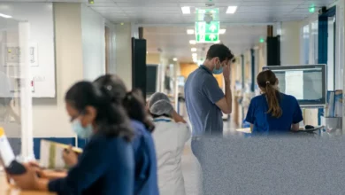 A busy hospital corridor with medical staff and patients, illustrating NHS pressure.