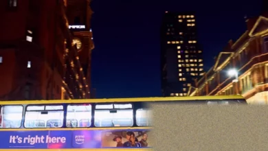 A Bee Network bus operating on a city street at night.