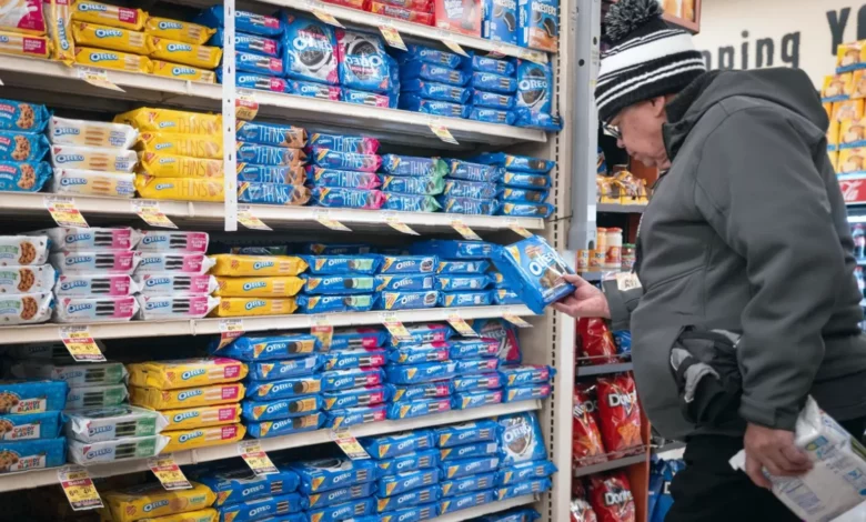 A shopping trolley filled with packaged snacks, ready meals, and fizzy drinks.