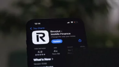 A smartphone displaying a fintech app with cryptocurrency and investment icons.