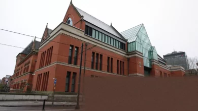 A courtroom sketch showing three defendants standing in the dock at Manchester Crown Court.