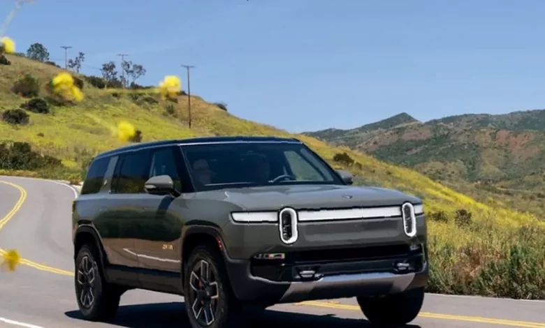 A sleek Rivian R2 autonomous vehicle on a city street.
