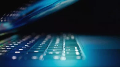 A small business owner looking at a laptop screen displaying a cybersecurity alert.