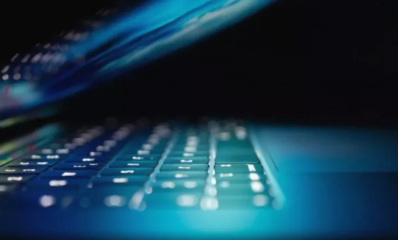 A small business owner looking at a laptop screen displaying a cybersecurity alert.
