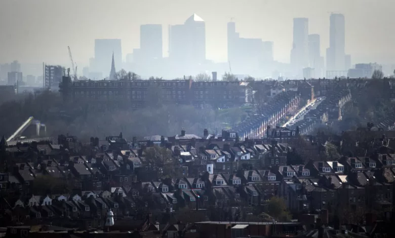A UK city street with heavy traffic and visible air pollution.