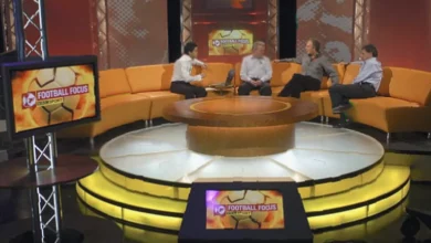 A football studio set with analysis screens and a presenter’s desk, empty before broadcast