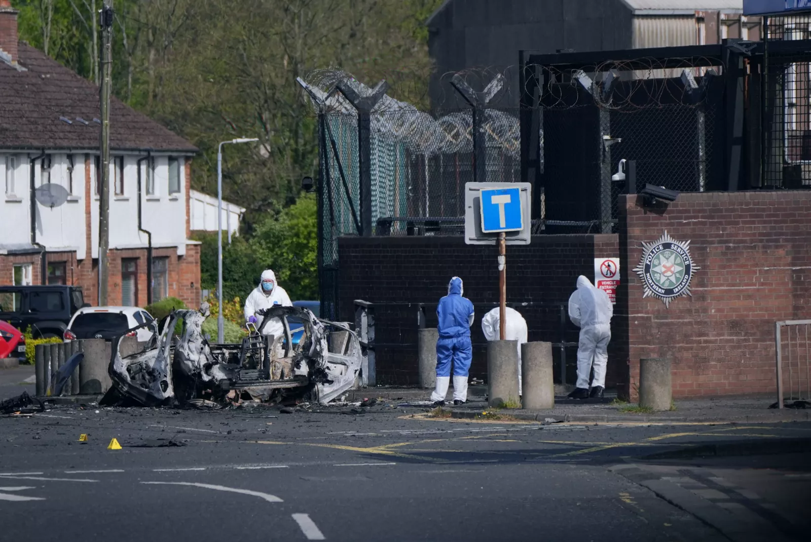 Damaged delivery vehicle engulfed in flames following bomb detonation at night