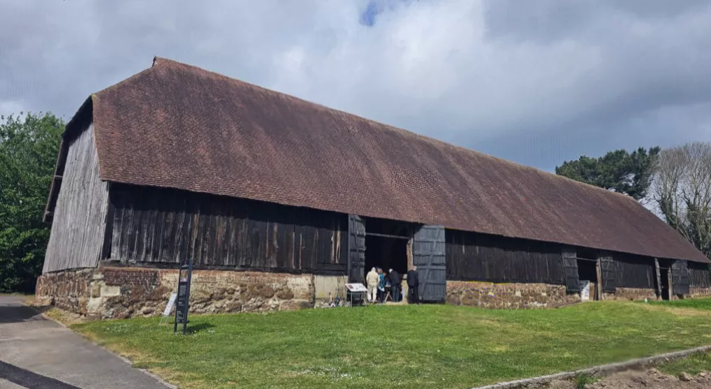 Exterior view of the Great Barn's weatherboarding and low masonry sill wall