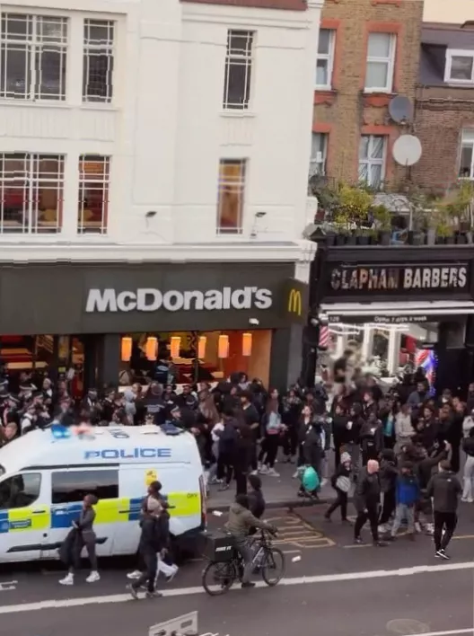 Aerial view of a large crowd gathering on a London high street.