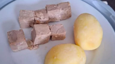 Cold jacket potato and small tuna portion on a hospital meal tray