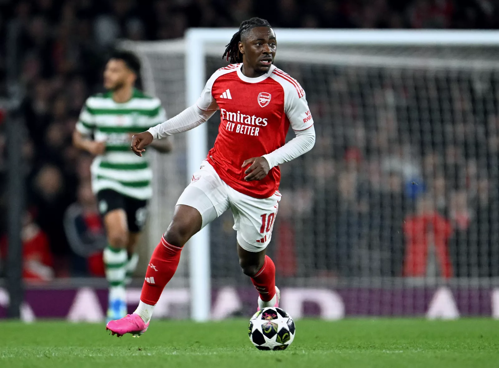 A tense Champions League match at the Emirates Stadium under floodlights.