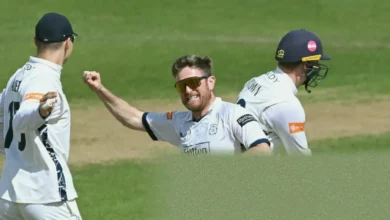 County cricket match in progress at a sunlit English ground.