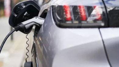 A line of new electric vehicles at a UK car dealership forecourt.