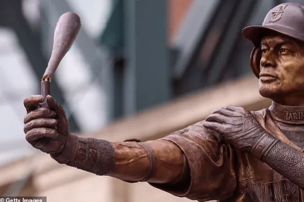 A bronze statue of a batter with a broken bat at a ballpark.