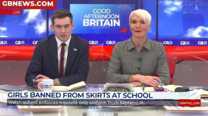 A rack of school uniform options including traditional shirts and modern hoodies.