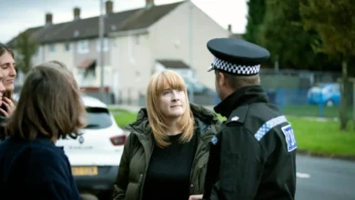 Police officers monitoring a large public demonstration in a UK city.