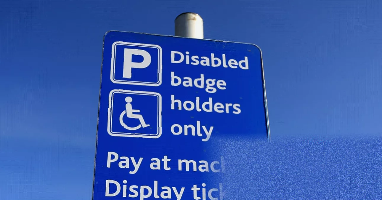 A disabled parking bay sign on a UK high street.