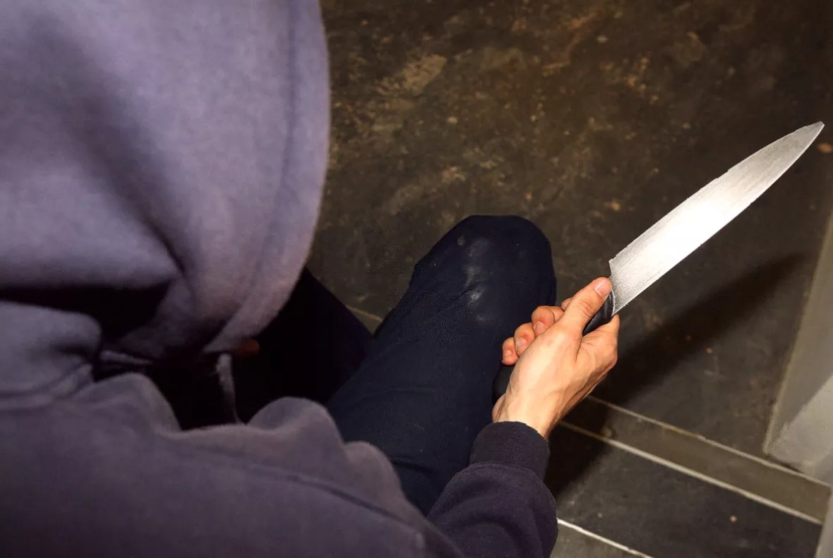 A knife detection arch set up at the entrance to a busy urban street.