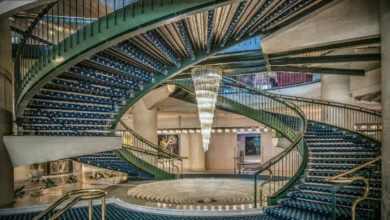 The grand lobby of a luxury hotel featuring classical artworks and tapestries on display.