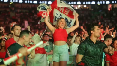 A busy London pub showing a late-night football match on large screens.