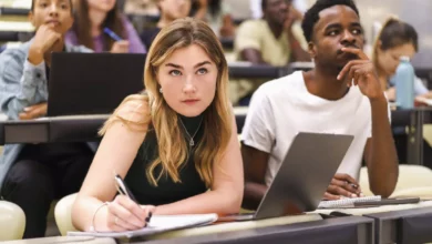 A student looking worriedly at a laptop screen showing a financial demand letter.