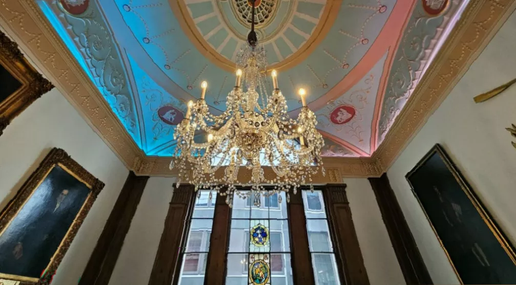 Traditional afternoon tea set within an elegant 18th-century hall interior.