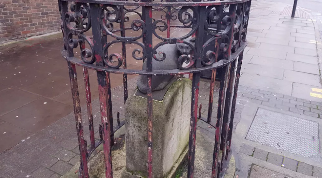 A heritage worker repainting the iron railings around the restored monument