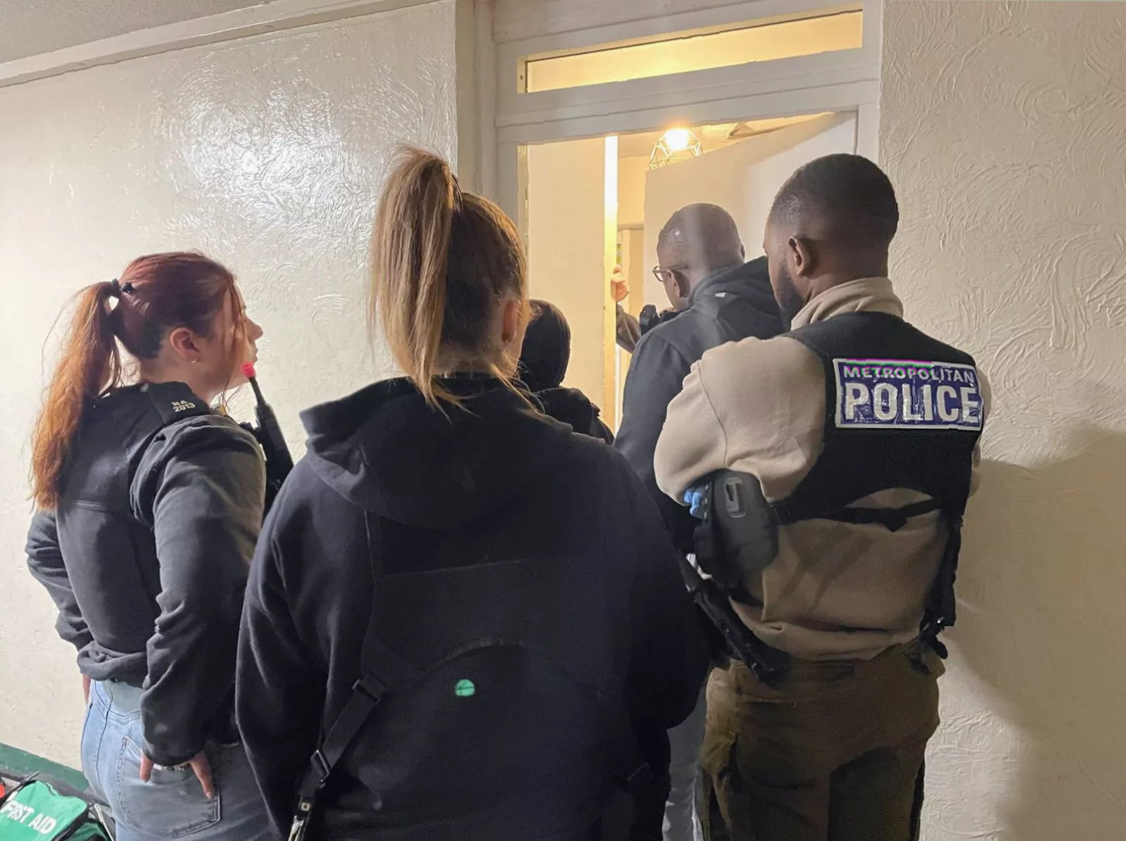 An enforcer battering ram being carried by police outside a block of flats