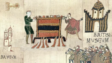 Visitors viewing the Bayeux Tapestry laid flat on a long display table at the British Museum