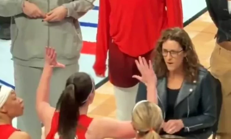 Basketball court during a WNBA game timeout with a coach and player in a tense exchange