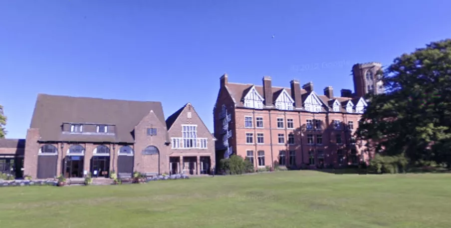 Students walking across a grassy courtyard at a university campus