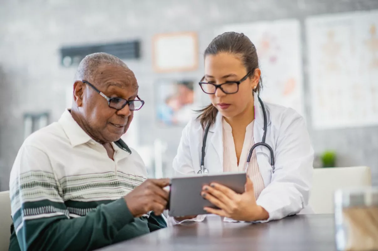 A family reviewing health insurance paperwork at a kitchen table, looking concerned.