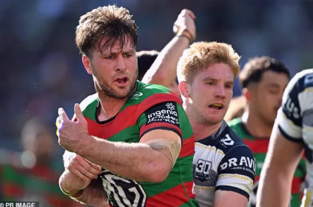 Rugby league player tackling an opponent during an NRL match at a packed stadium