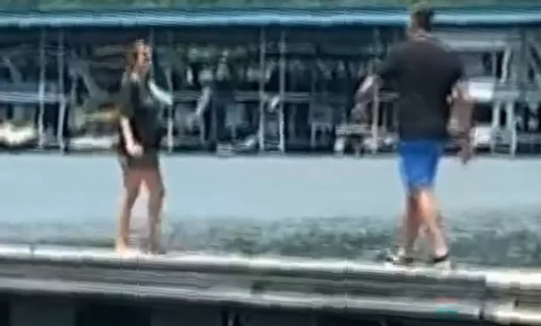 A pregnant woman and a man walking along a wooden dock in Tennessee