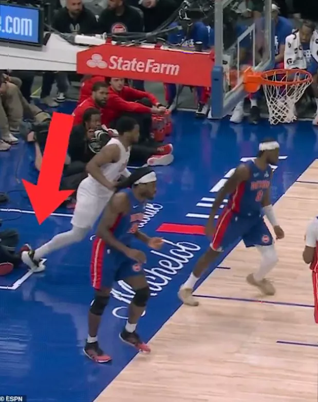 Courtside photographer seated along baseline during NBA playoff game in Detroit