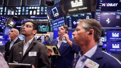 Traders on the floor of the London Stock Exchange watching FTSE 100 index boards