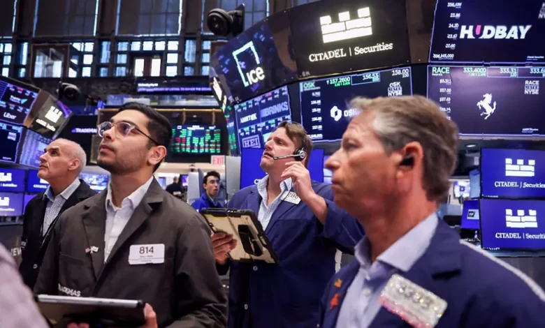 Traders on the floor of the London Stock Exchange watching FTSE 100 index boards